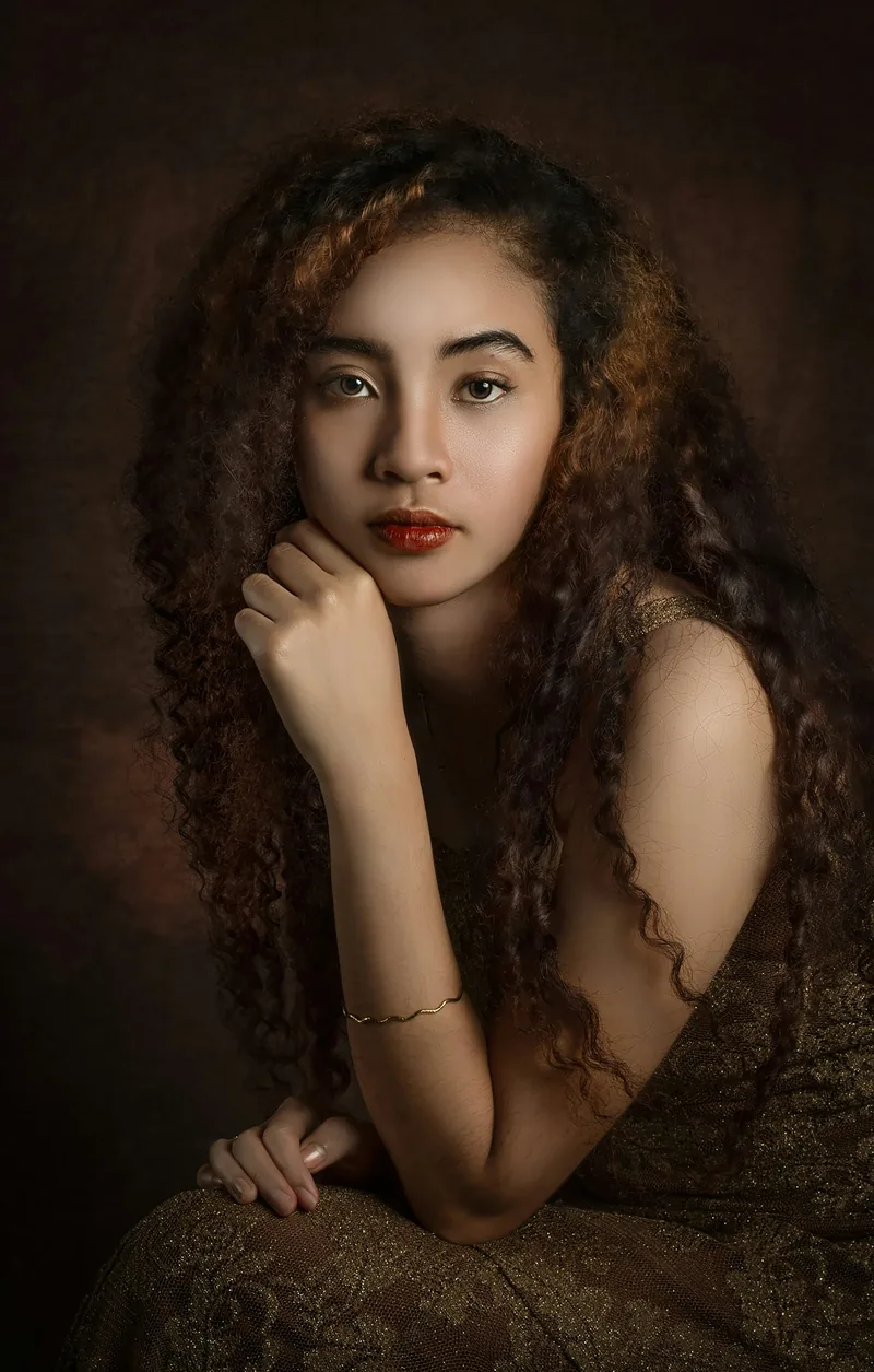 Painterly low-key portrait of a woman with long curly hair